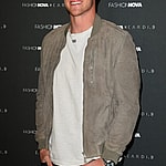 Logan Paul smiling in a green jack on the red carpet.