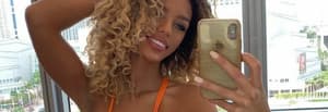 Jena Frumes takes a selfie in front of a city skyline window