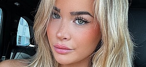 Emily Elizabeth snaps a selfie inside her car while wearing a plunging black top.