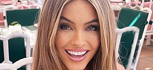 Chrishell Stause smiles at an outdoor table