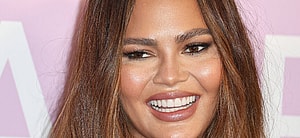 Chrissy Teigen smiles at an event