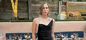 A photo showing Tommy Dorfman rocking a mini black dress.