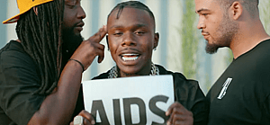 DaBaby holding up a sign that says AIDS