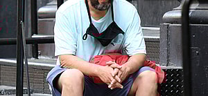 Adam Sandler holds a basketball and sits down to rest after a game in NYC