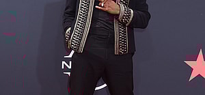 Singer Ne-Yo posing on the red carpet at the BET Awards in 2022.
