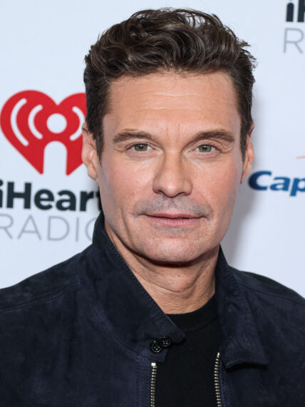 Ryan Seacrest posing for a photo on the red carpet.