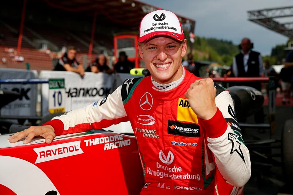 Mick Schumacher celebrates after a racing victory in red Theodore Racing suit