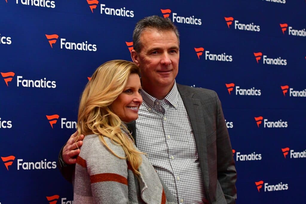 Urban Meyer and a woman posing together at a Fanatics event