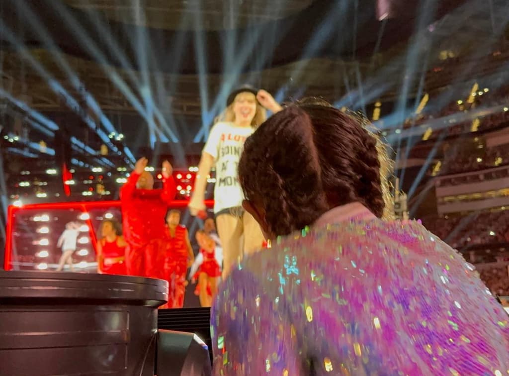 Taylor Swift walking to Bianka Bryant to give her 22 hat