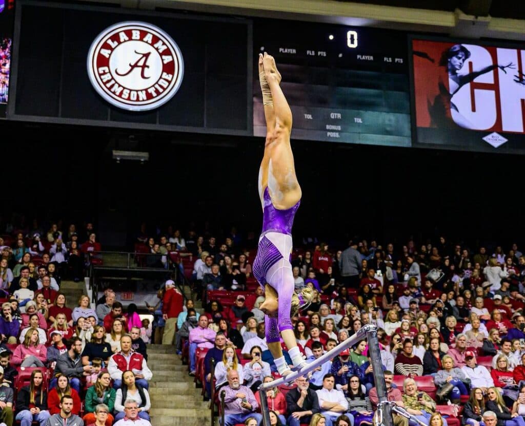 Olivia Dunne doing a handstand on the uneven bars.