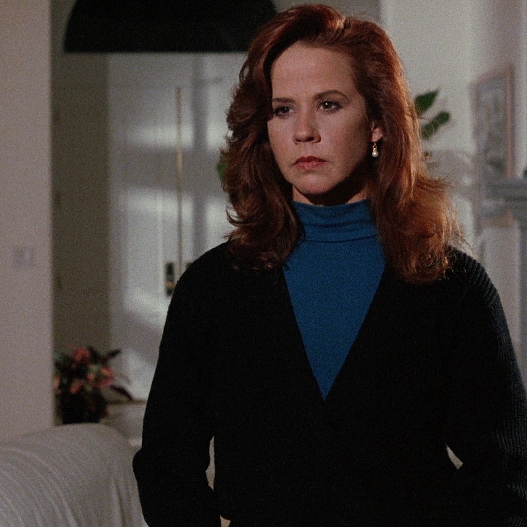 A throwback photo of Linda Blair sporting a black jacket over a blue turtleneck shirt.