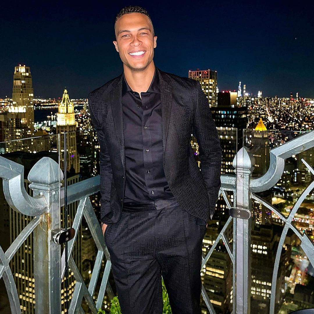 A photo showing Dale Moss in a black suit and inner T-shirt with a smile on his face.