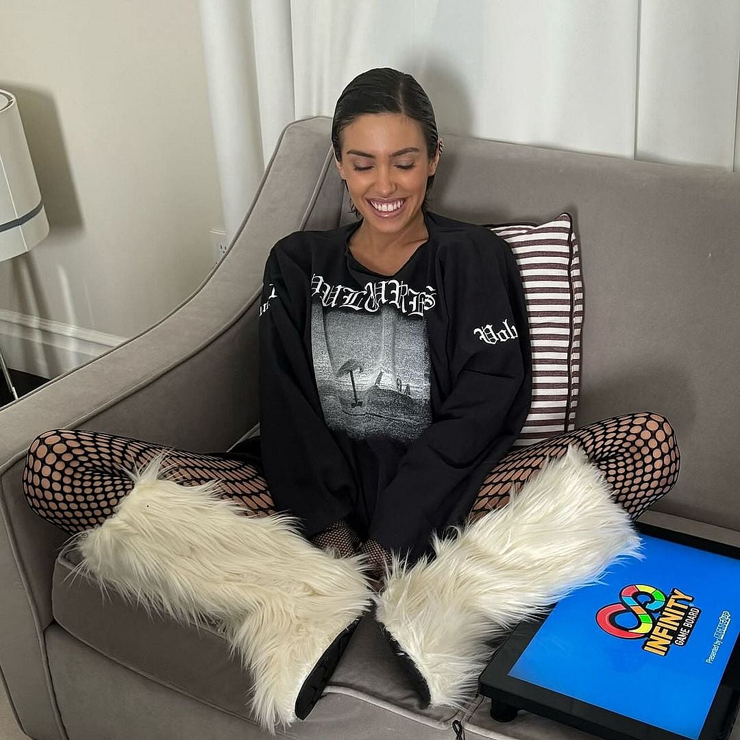 Kanye West's Wife Bianca Censori smiling with her eyes closed on a couch
