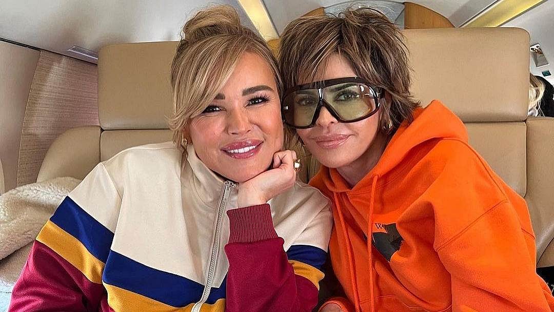 two women cozied up smiling