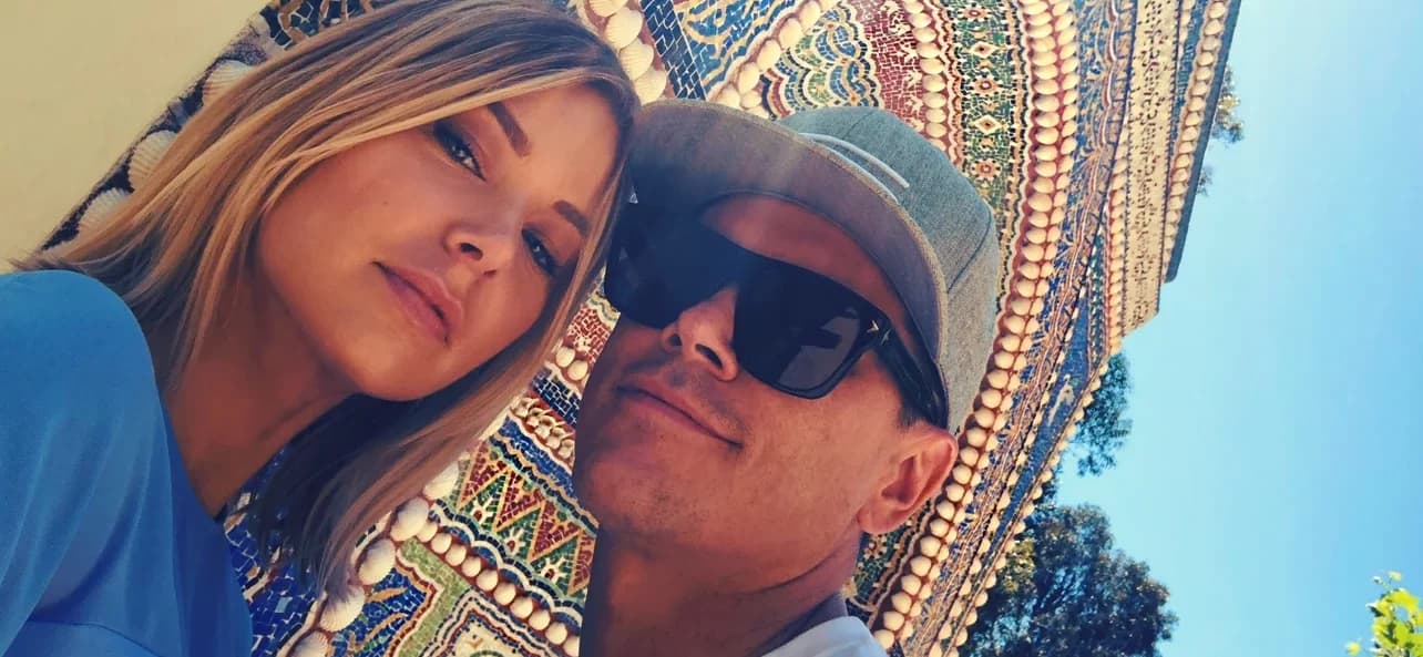 tom and ariana selfie in front of a mosaic