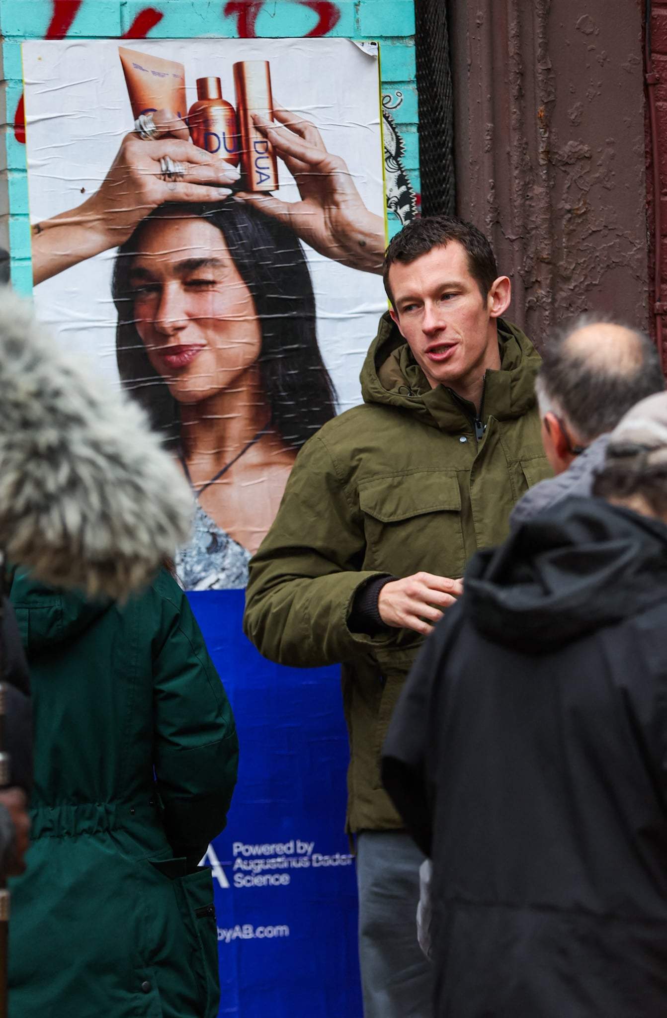 Callum Turner is seen standing next to a poster of Dua Lipa while on set of his new movie One Night Only this afternoon in New York City