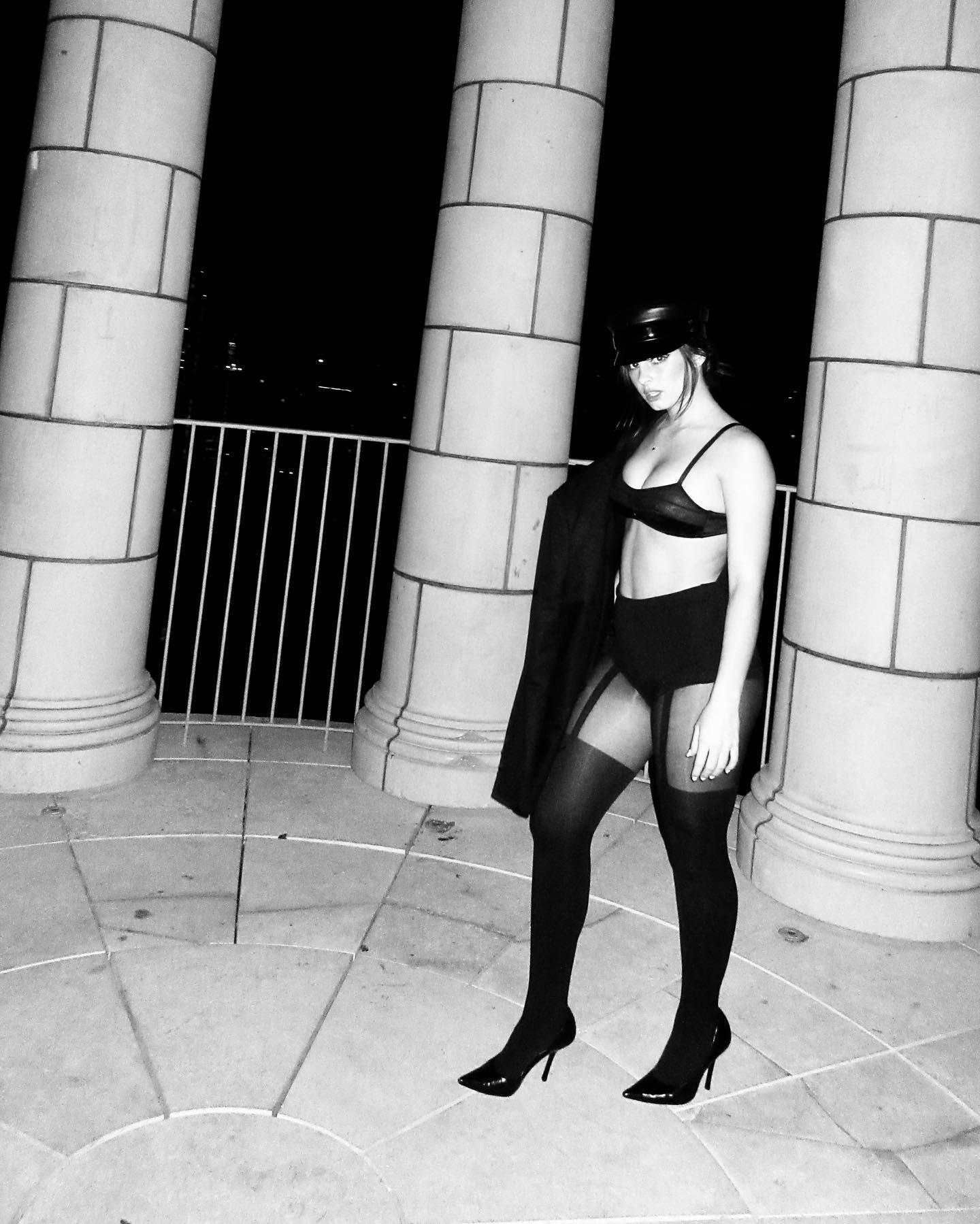 Addison Rae poses in a black bra and heels