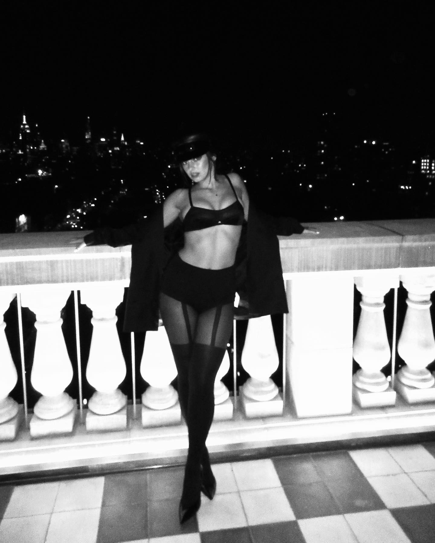 Addison Rae poses in a black bra and heels