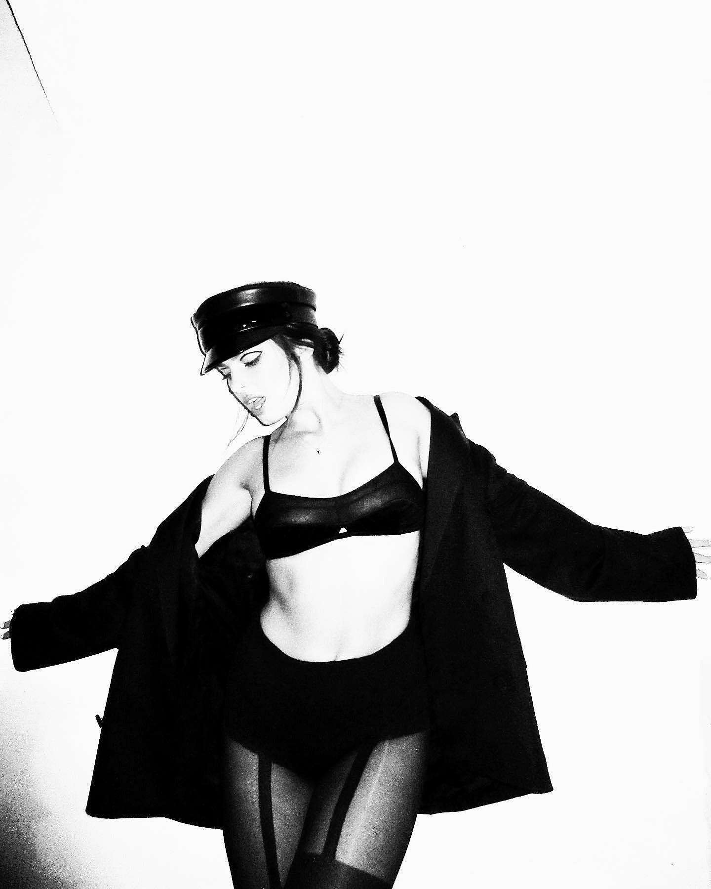 Addison Rae poses in a black bra and heels