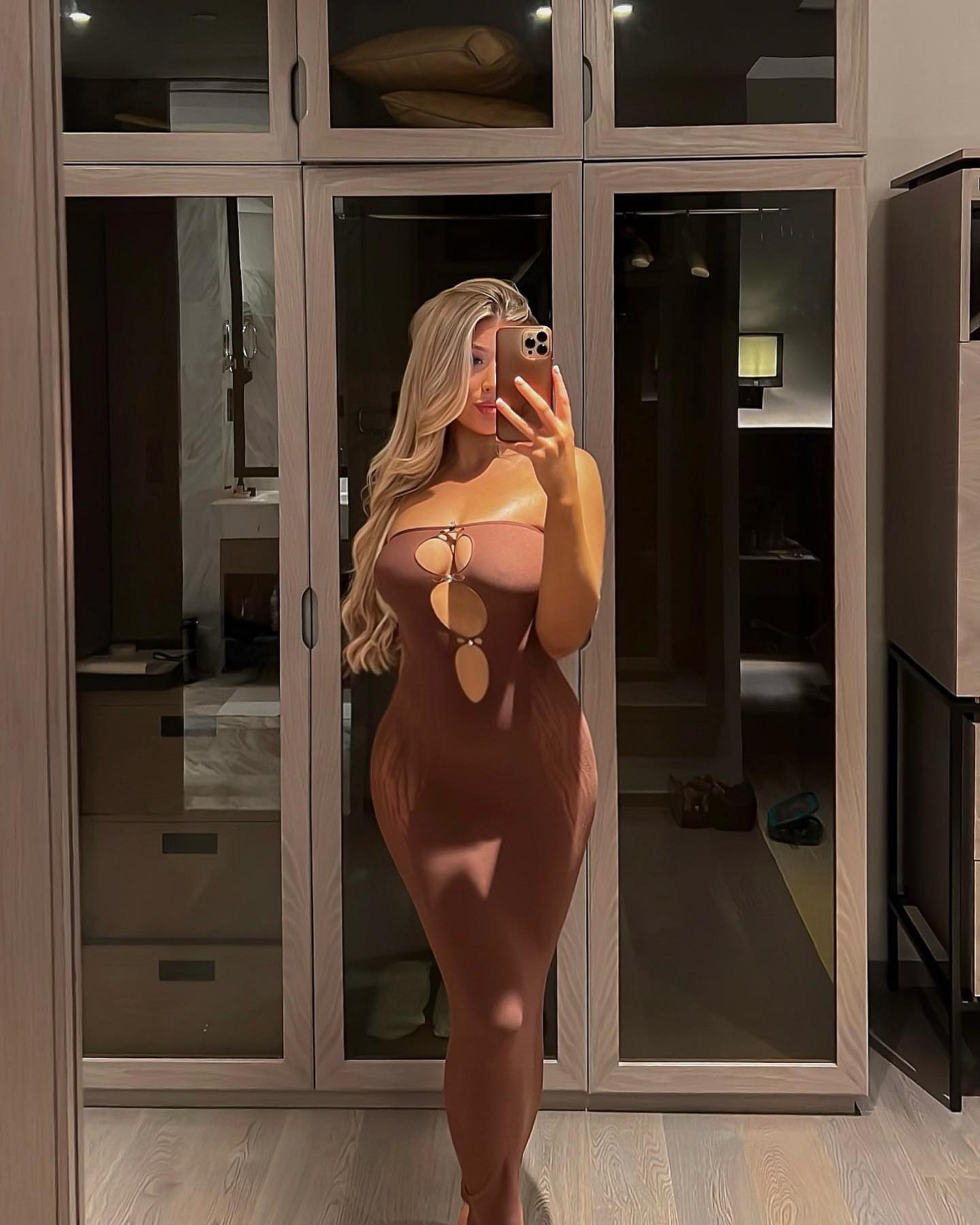 Eve Gale poses in a sheer brown dress 