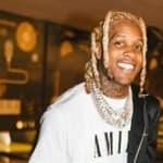 A photo showing Lil Durk smiling at the camera at an event.
