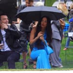 Megan Fox stuns in blue as she stares into the cameras while holding an umbrella in the rain during the Moschino fashion show held outside during fashion week in NYC