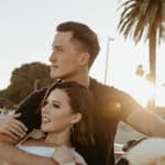 Katie Thurston and John Hersey relax around palm trees