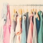 Women's summer clothes hanging in a closet.
