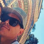 tom and ariana selfie in front of a mosaic