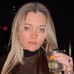 Julz Dunne posing for the camera while holding her drink.