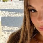 Grace Boor takes a selfie in her white bikini at the beach.