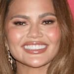 Chrissy Teigen smiles at an event