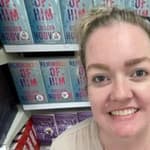 Colleen Hoover smiling in front of books