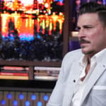 Jax Taylor in a grey suit sitting on the set of Andy Cohen's 'Watch What Happens Live.'