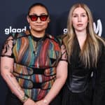Raven Symoné and her wife posing on red carpet.