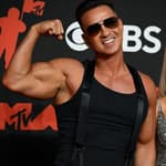 Mike "The Situation" Sorrentino posing with his biceps on the red carpet.