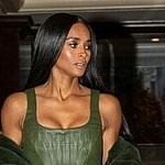 A photo showing Ciara coming down a flight of stairs in a green three-piece outfit