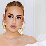 A photo showing Adele in a white off-shoulder dress.