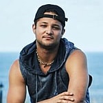 A photo showing Chris Pearson in a sleeveless hoodie and denim pant.