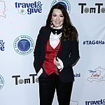 A photo showing Lisa Vanderpump sporting a black suit paired with a red and white inner-wear and black bow tie.