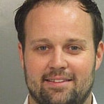 Reality star Josh Duggar smiles in this new mugshot photograph after being found guilty today