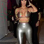 Kim Kardashian wears a silver latex bikini top with matching leggings as she and sister Khloe Kardashian arrive to her Skims pop-up event in Miami