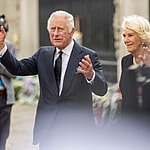 King Charles III and Queen Consort Camilla look at floral tributes left for Queen Elizabeth II outside Buckingham Palace in central London