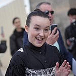 Bella Ramsey Greets Fans at Exit Of Paris Dior Show in Print Overalls Look