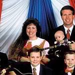 Jim Bob Dugger and his wife Michelle pose with there 13 children in this family photograph