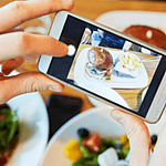 Taking picture of table of food