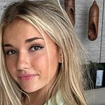 Breckie Hill poses for the camera on the bed.