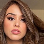 Yanet Garcia poses for the camera in a white bath robe.