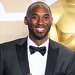 Kobe Bryant holding trophy in a tux