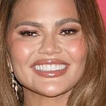 Chrissy Teigen smiles at an event